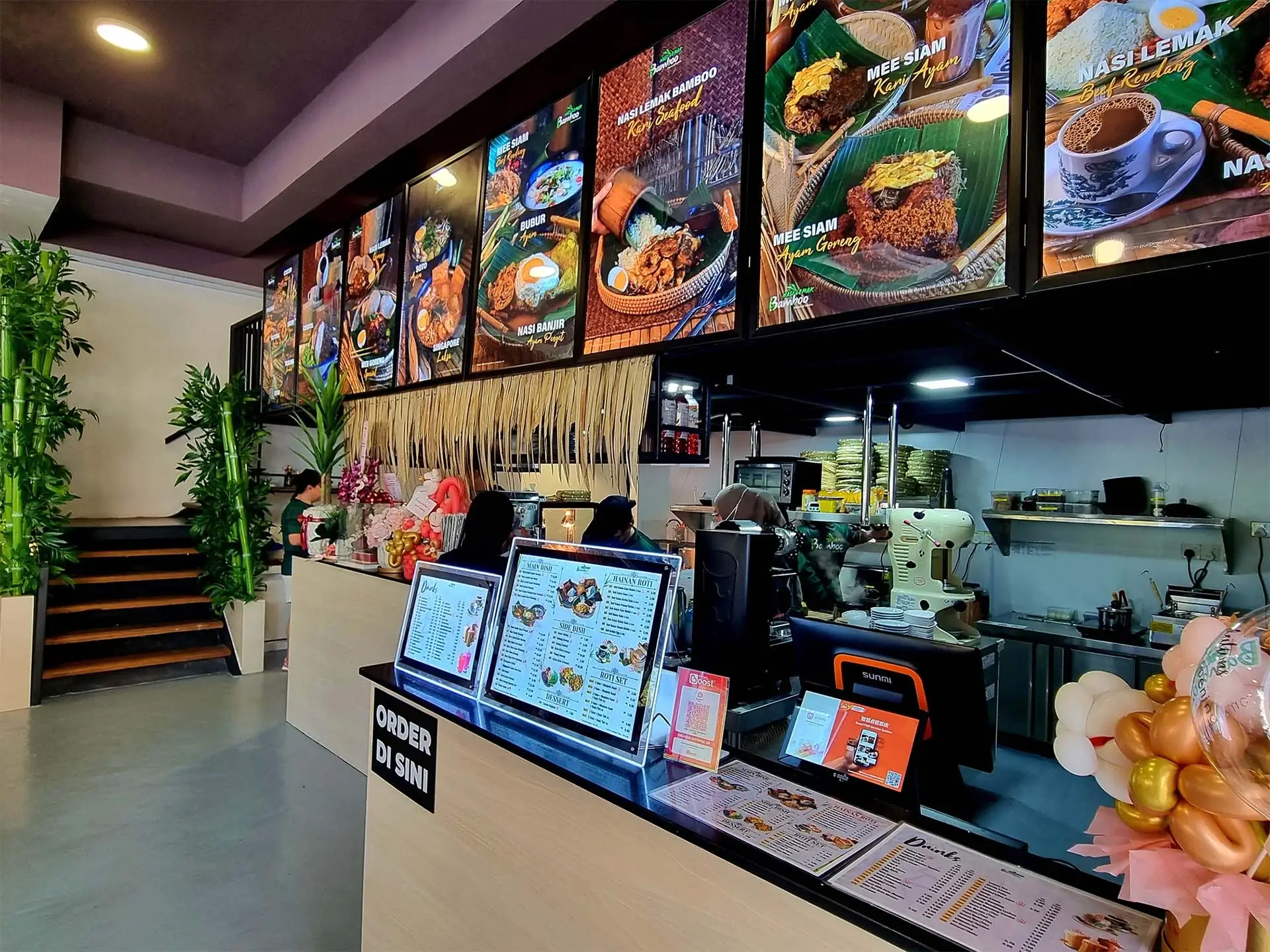 Inside a Nasi Lemak Bamboo outlet: menu boards, counter and bamboo-lined dining area